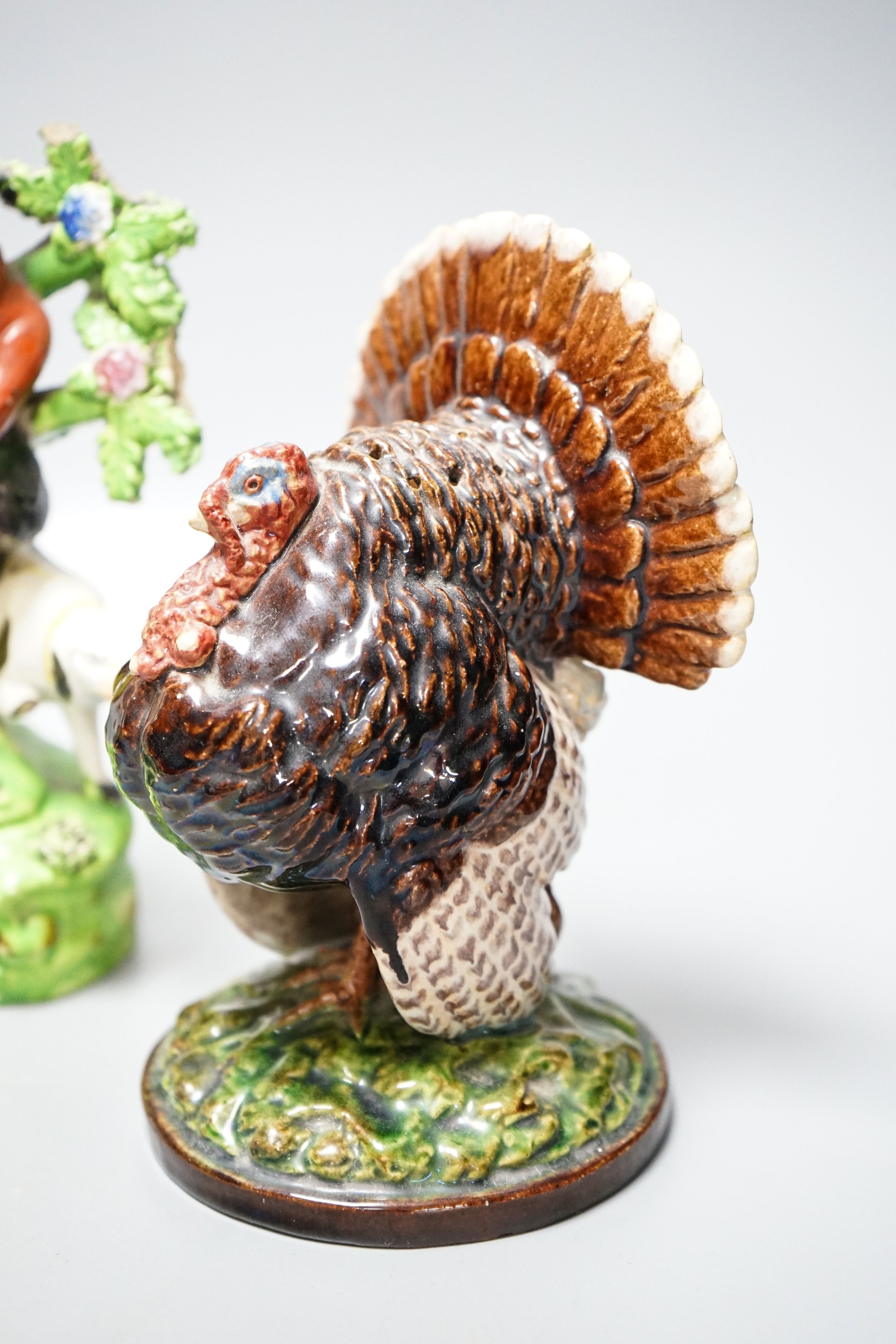A 19th century 'Milkmaid and cow' creamer with sponged decoration, three other Staffordshire items and a Continental majolica figure of a turkey (5)